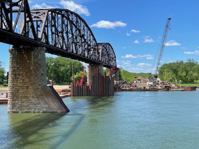 Evidence of work on the new bridge starts to emerge from the water next to the existing bridge.