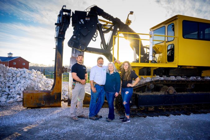 Pictured from left: Elizabeth’s brother, Adam; father, Wayne; mother, Lori; and Elizabeth standing with their plow used for installing soil drainage 